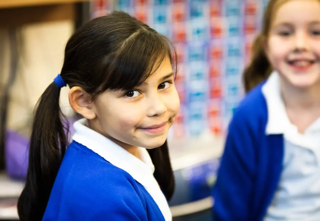 Smiling schoolgirl in uniform.
