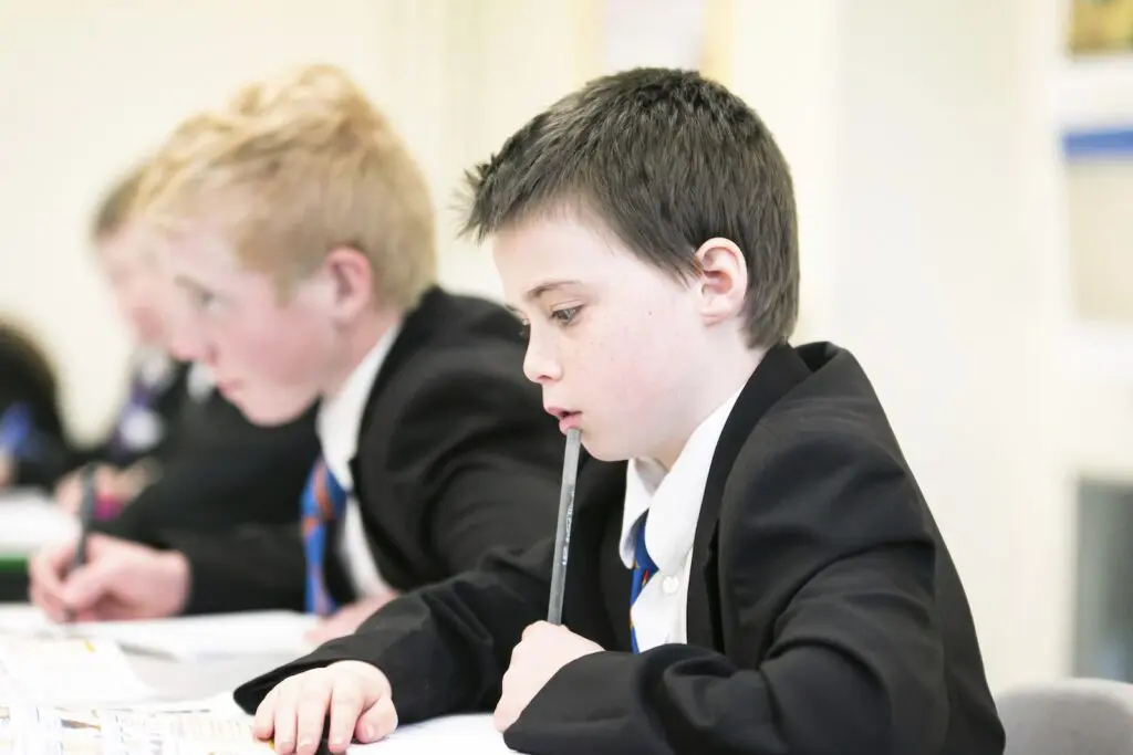 Teacher working with students in a classroom setting.