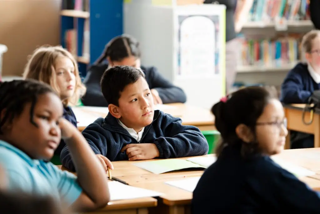 Students attentively listen in a classroom setting.