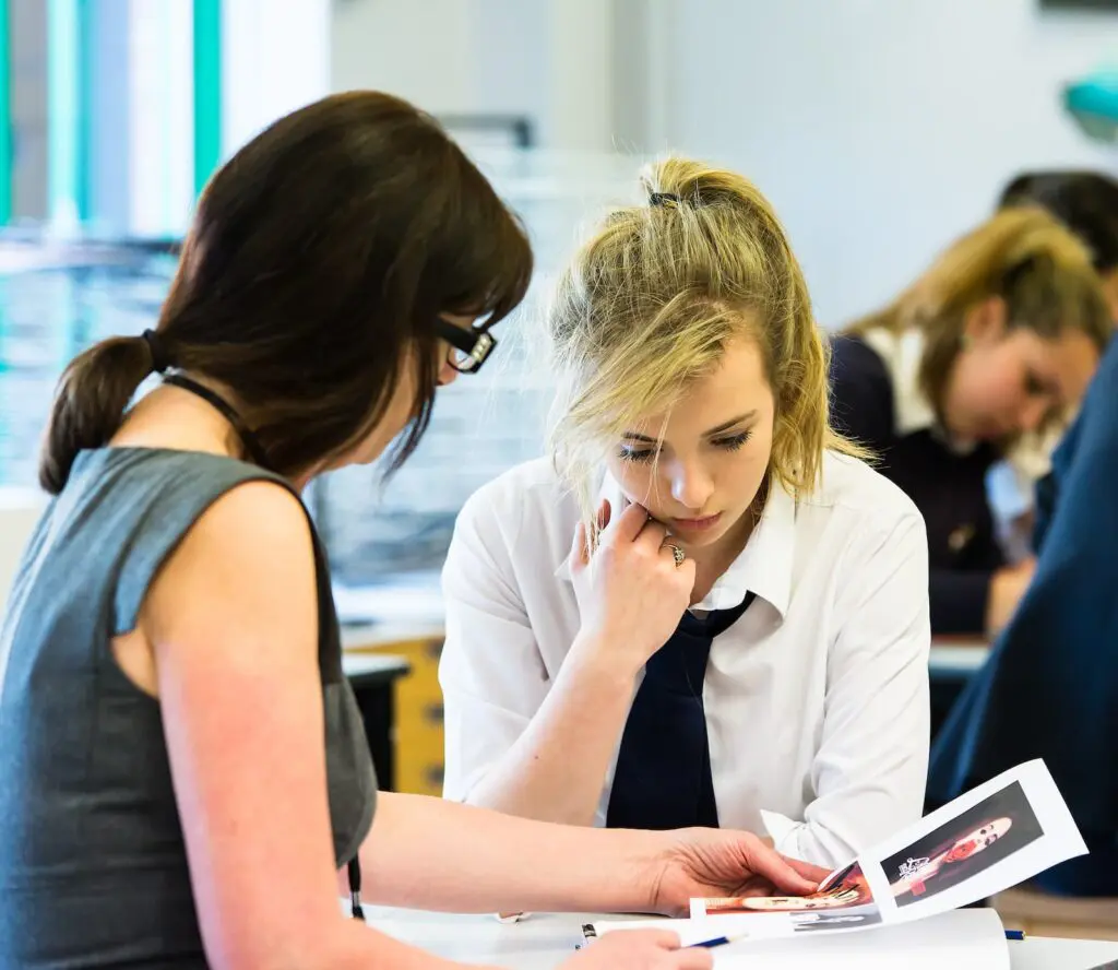 A teacher and student reviewing photography.