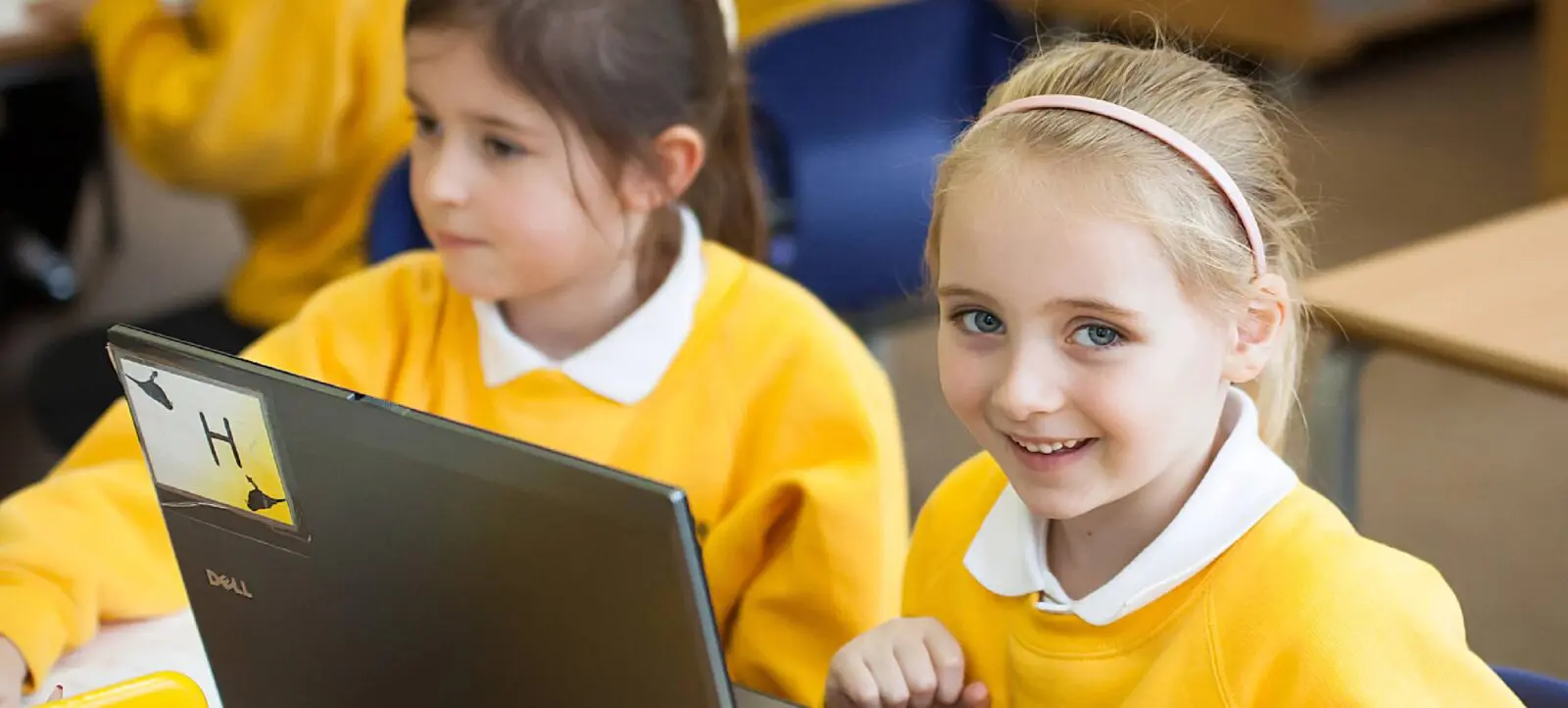 Young girl smiling using laptop