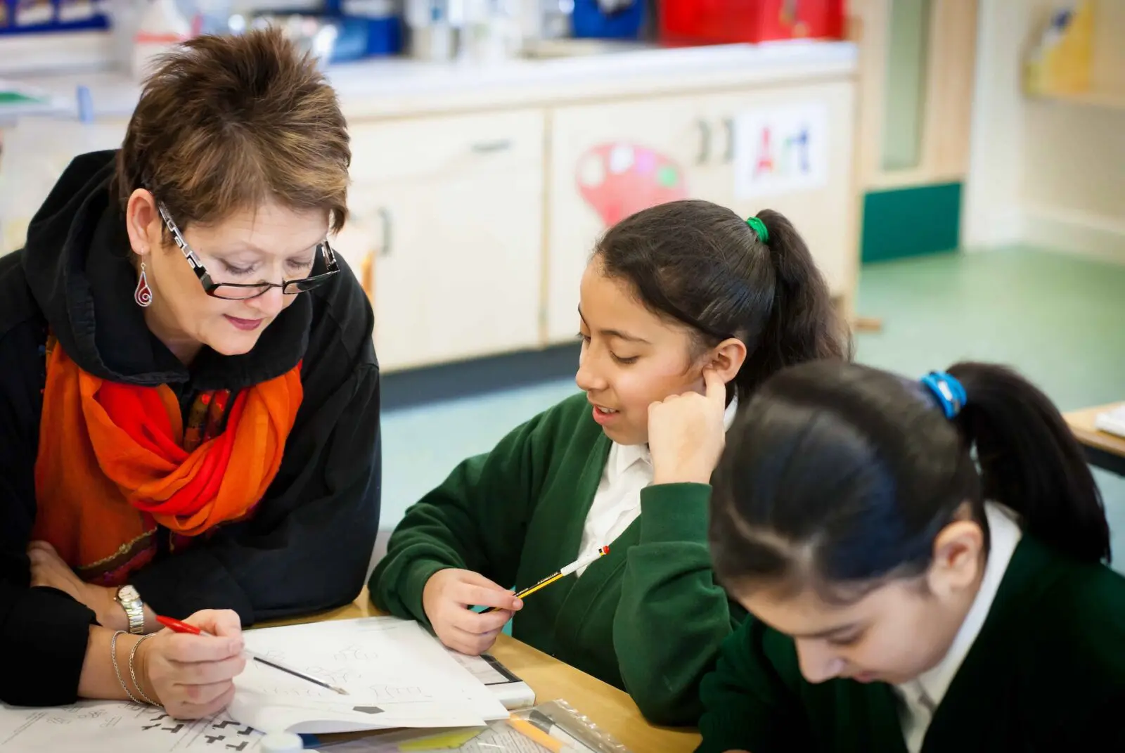 Teacher helping students in classroom