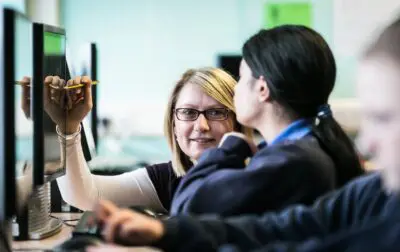 Teacher helping student at computer